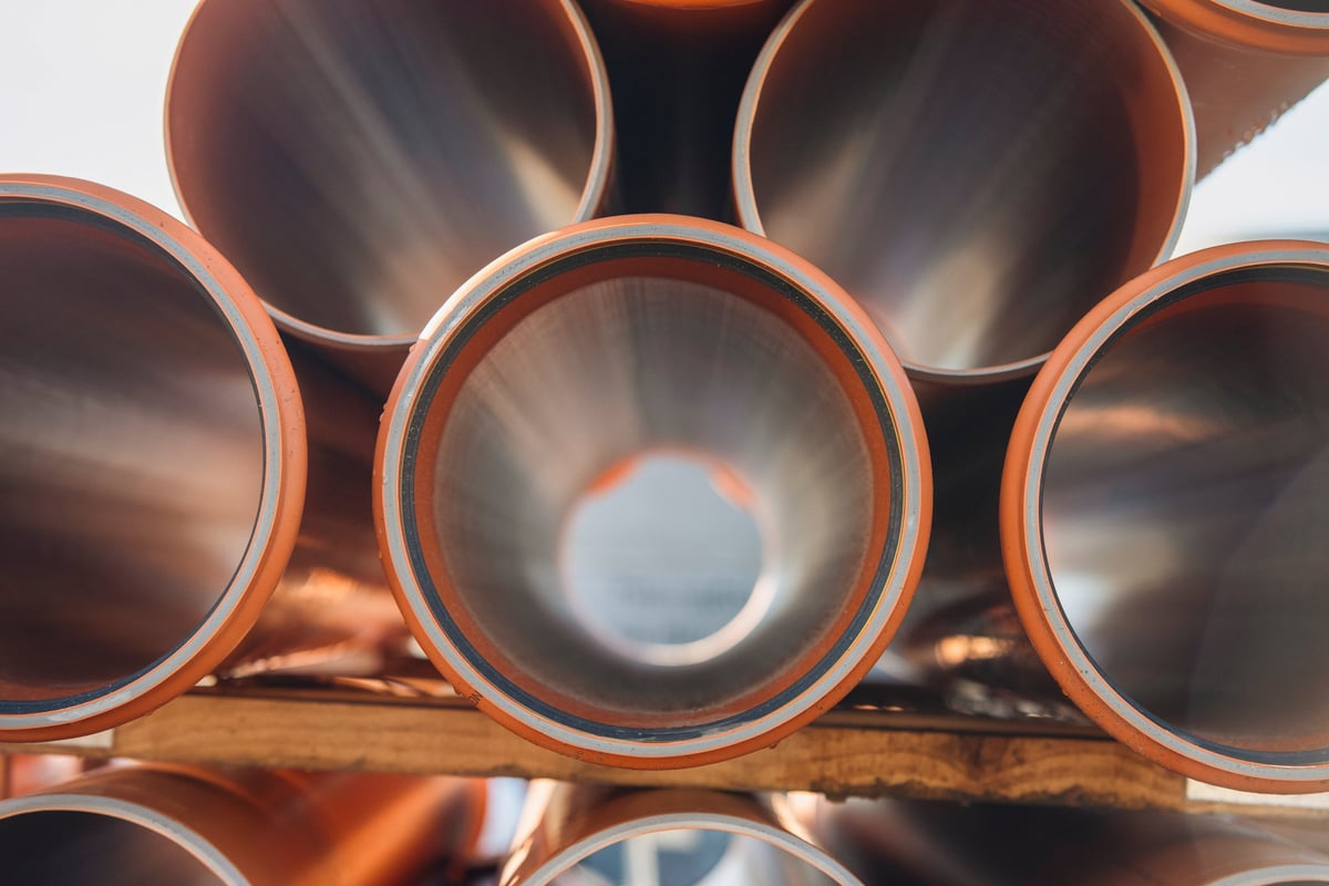 Plastic drainage pipes arranged in stack at construction site